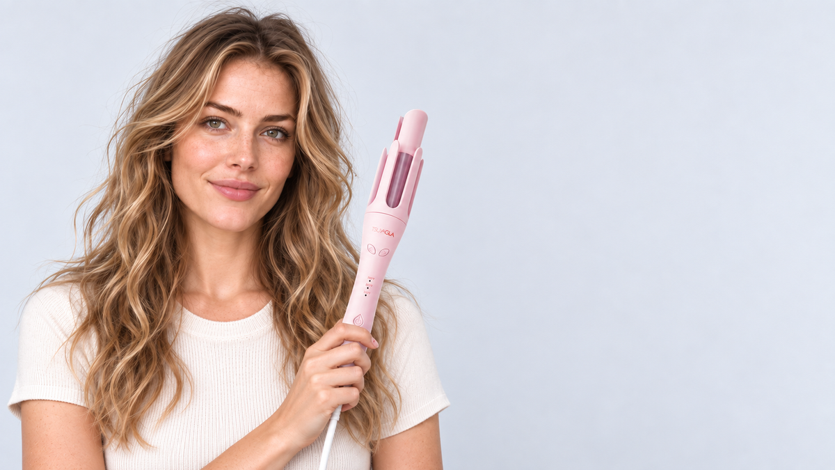 Front-facing model holding the pink automatic curler with softly waved hair
